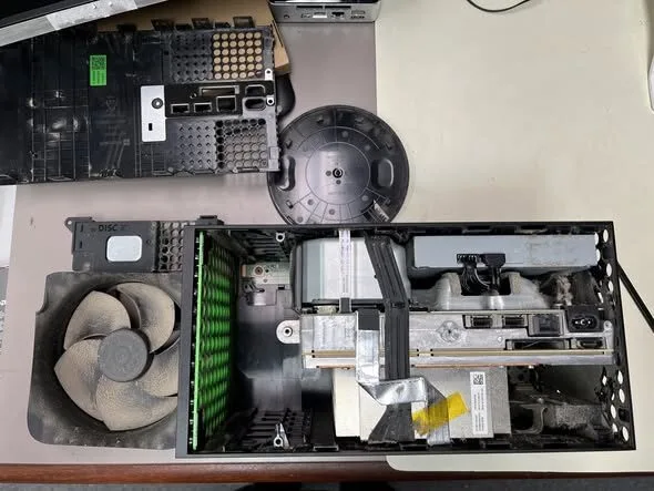 Opened game console showing its fan, board, and internal components