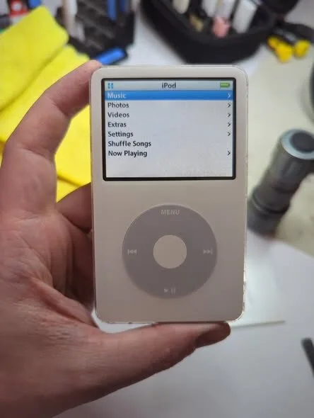 Classic iPod being held at the repair bench