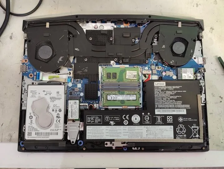 Open laptop showing its motherboard, memory, storage, and cooling system